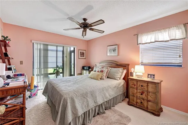 a bedroom with a bed a chandelier and a window