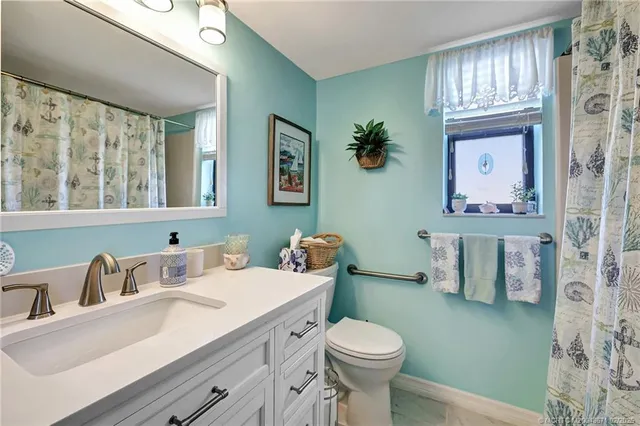 a bathroom with a sink a toilet and mirror