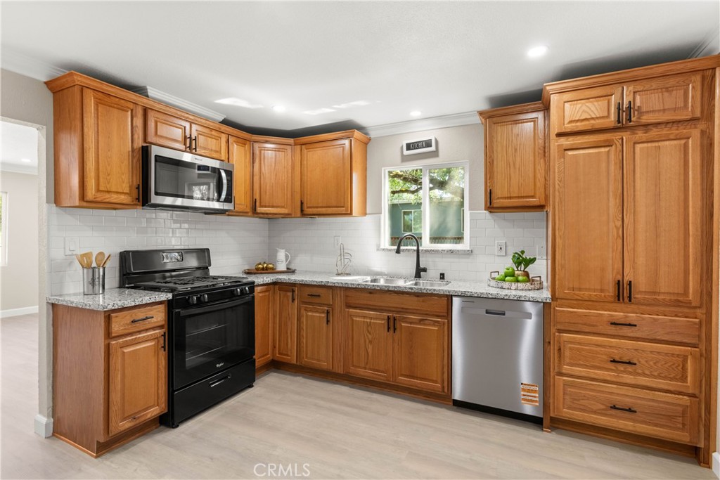 4936 Lower Wyandotte Road Oroville, CA 95966 - Photo 10 of 41 a kitchen with stainless steel appliances granite countertop wooden cabinets and a stove top oven