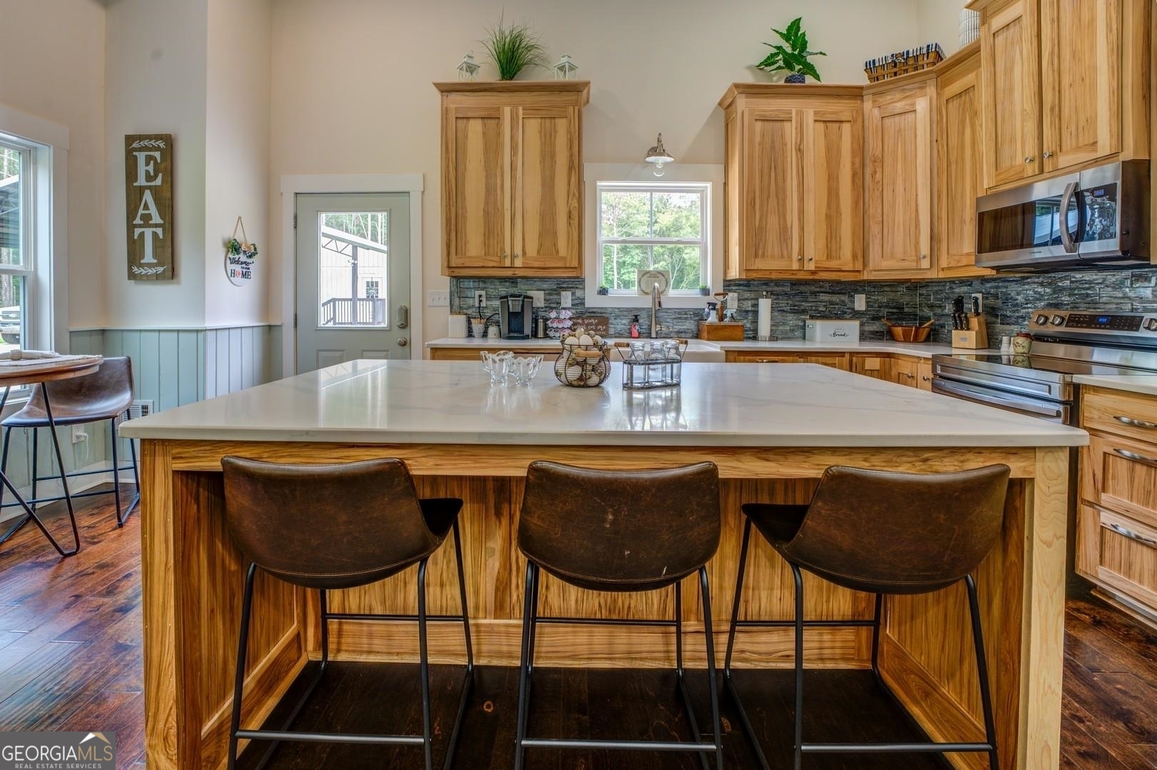 3060 Eatonton Road Madison, GA 30650 - Photo 11 of 65 a kitchen with stainless steel appliances granite countertop a table chairs sink and cabinets