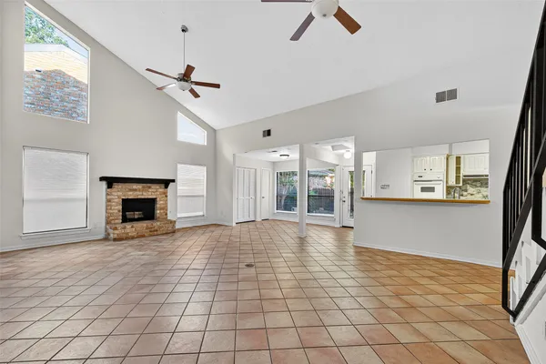 a view of an empty room with window and fireplace