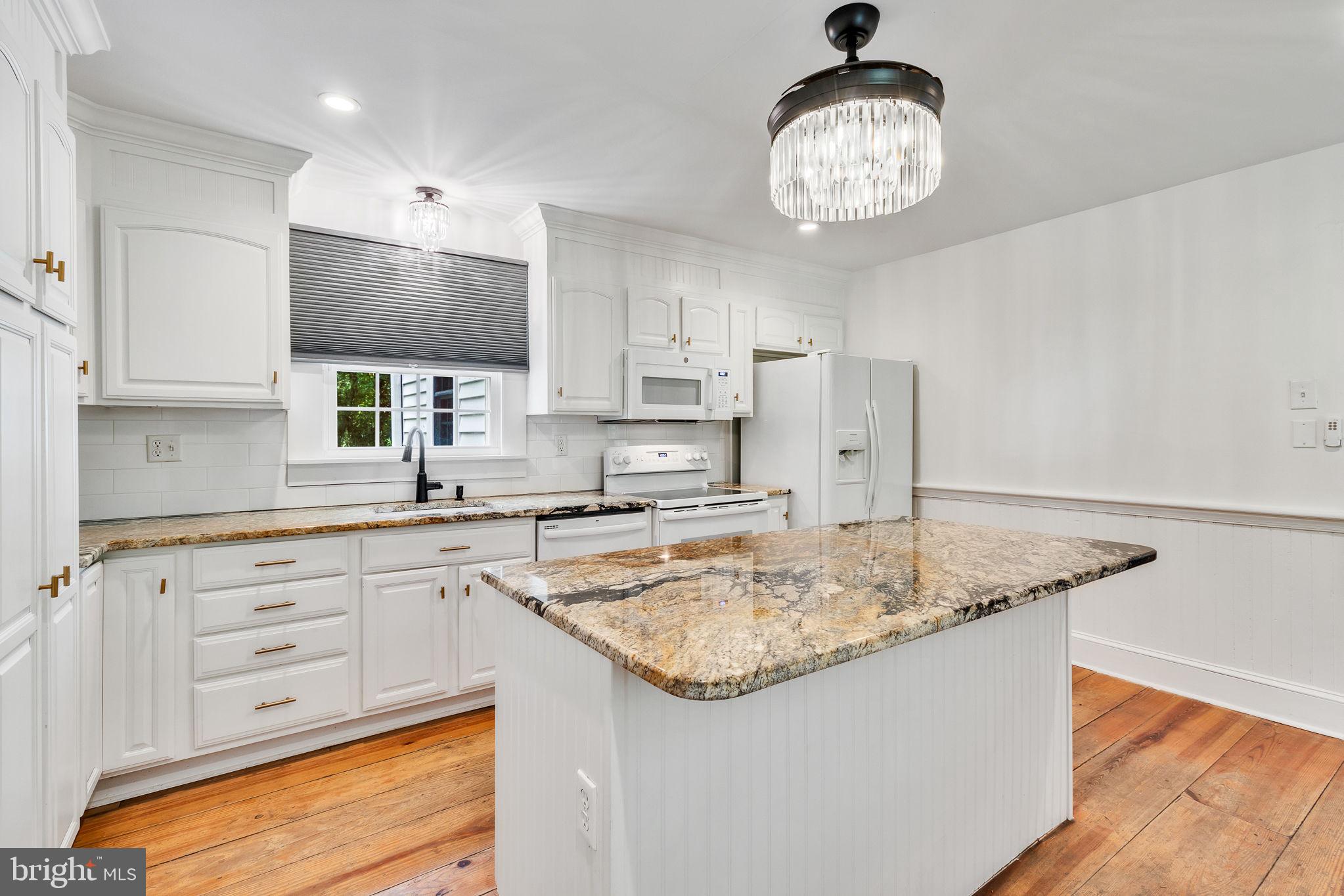 3952 Irvington Road Irvington, VA 22480 - Photo 16 of 77 a kitchen with stainless steel appliances granite countertop a sink a refrigerator and a stove top oven