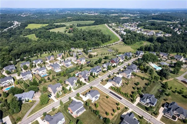 an aerial view of residential houses with outdoor space and trees