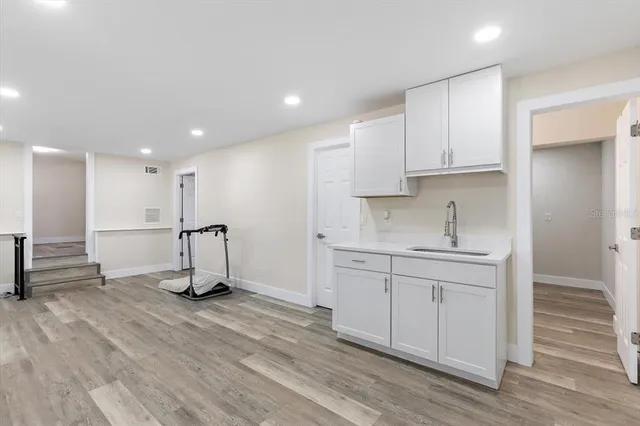 a view of kitchen with sink stainless steel appliances and cabinets