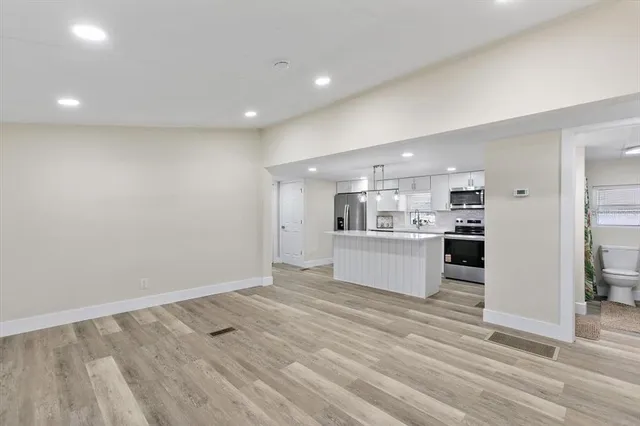 a view of kitchen with kitchen island white cabinets and wooden floor