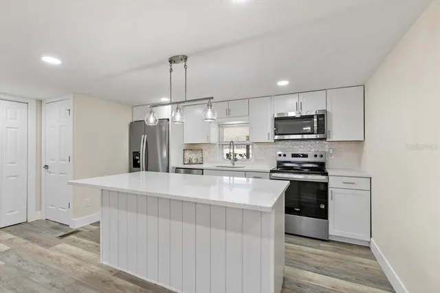 a kitchen with stainless steel appliances a refrigerator sink and stove