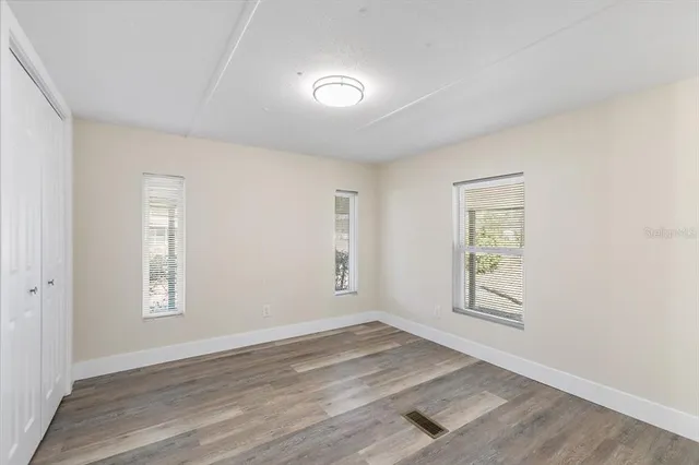 an empty room with windows and closet