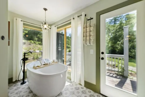 a bedroom with a bed and large windows