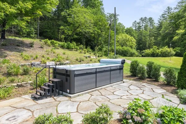 a backyard of a house with a yard with plants and large trees