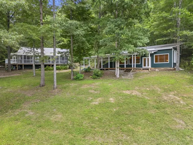 a backyard of a house with lots of green space and lake view