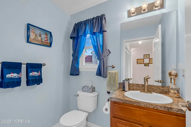 a bathroom with a granite countertop sink a toilet and a mirror