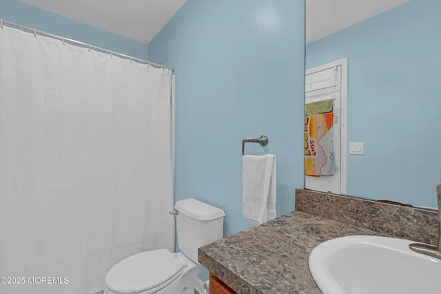 a bathroom with a sink toilet and mirror