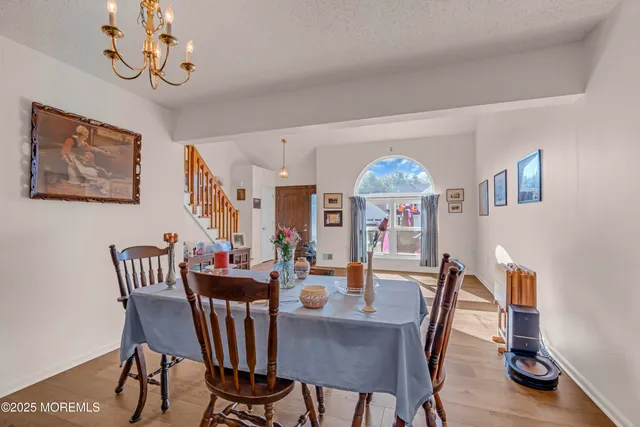 a view of a dining room with furniture wooden floor and a chandelier