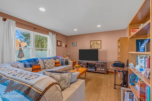 a living room with furniture a bookshelf and a flat screen tv