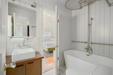 a bathroom with a sink a tub and a mirror