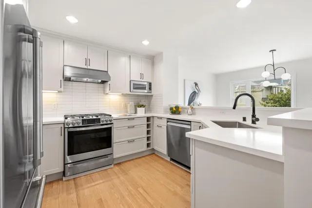 a kitchen with stainless steel appliances granite countertop a sink stove and refrigerator