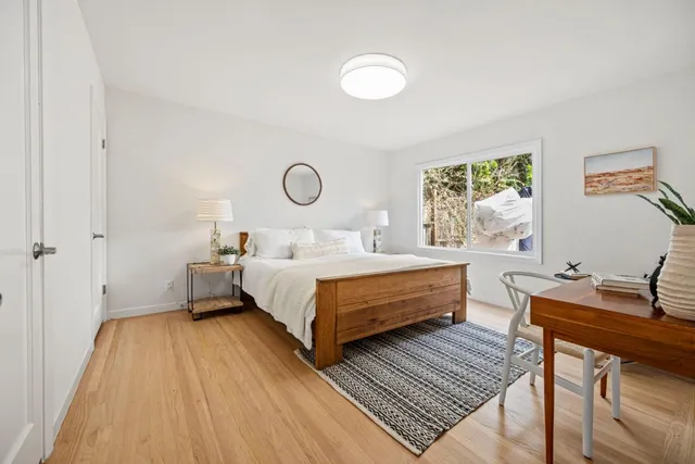 a bedroom with a bed and wooden floor