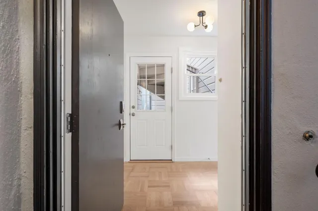 a view of a hallway with wooden floor