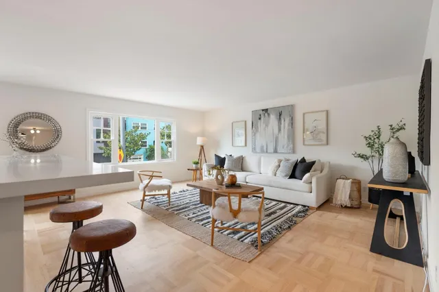 a living room with furniture a table and a large window