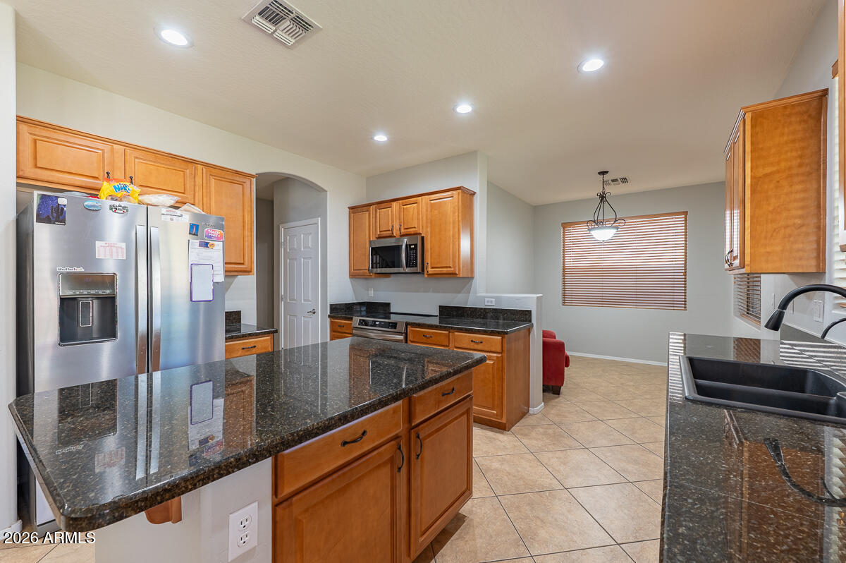 3328 East Merlot Street Gilbert, AZ 85298 - Photo 13 of 48 a kitchen with stainless steel appliances granite countertop a sink a stove and a refrigerator