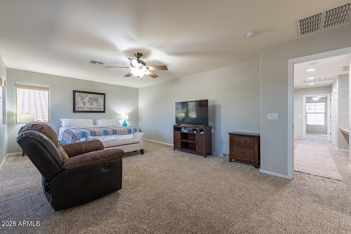 3328 East Merlot Street Gilbert, AZ 85298 - Photo 25 of 48 a living room with furniture a chandelier and a flat screen tv
