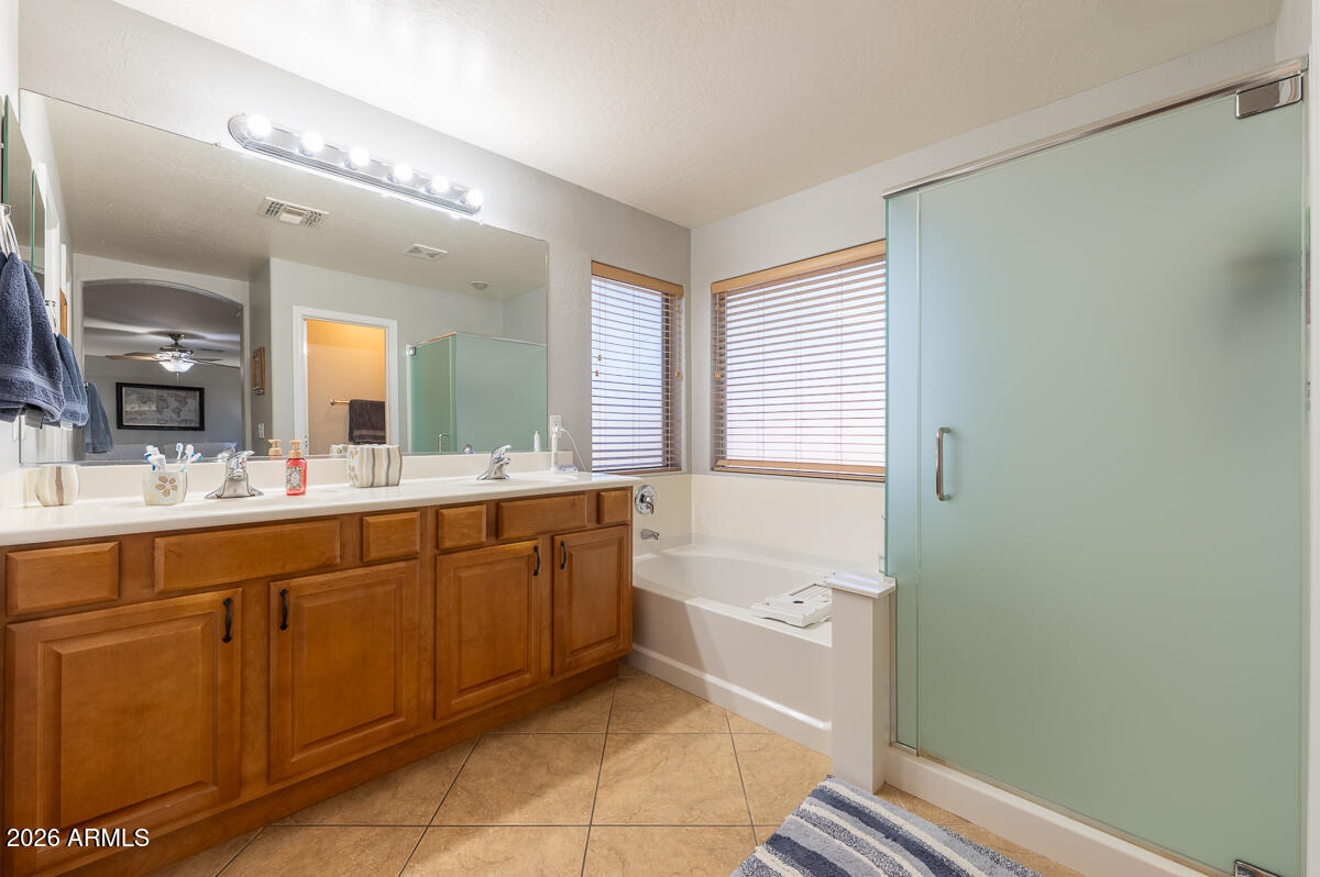 3328 East Merlot Street Gilbert, AZ 85298 - Photo 27 of 48 a spacious bathroom with a bathtub sink and mirror