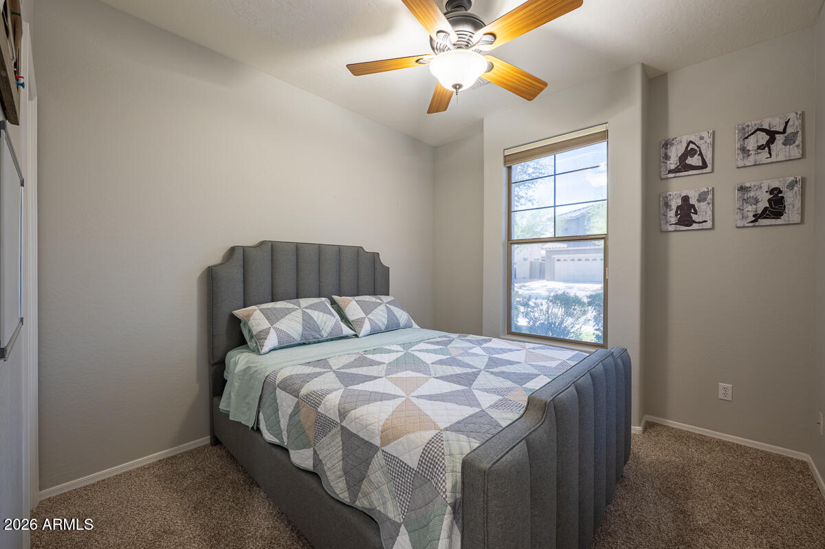 3328 East Merlot Street Gilbert, AZ 85298 - Photo 35 of 48 a bedroom with a bed and a chandelier