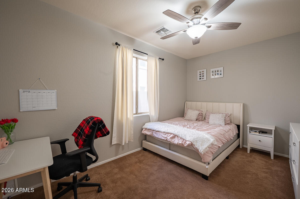 3328 East Merlot Street Gilbert, AZ 85298 - Photo 38 of 48 a bedroom with a bed and a chandelier