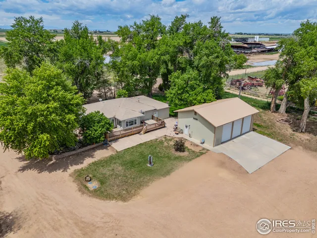an aerial view of a house with a yard and trees all around