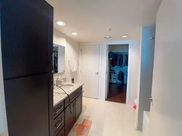 a kitchen with granite countertop a refrigerator and a sink