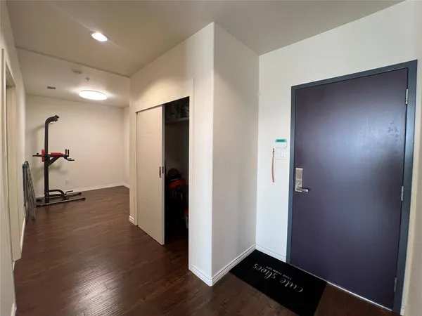 a view of a hallway with wooden floor and closet