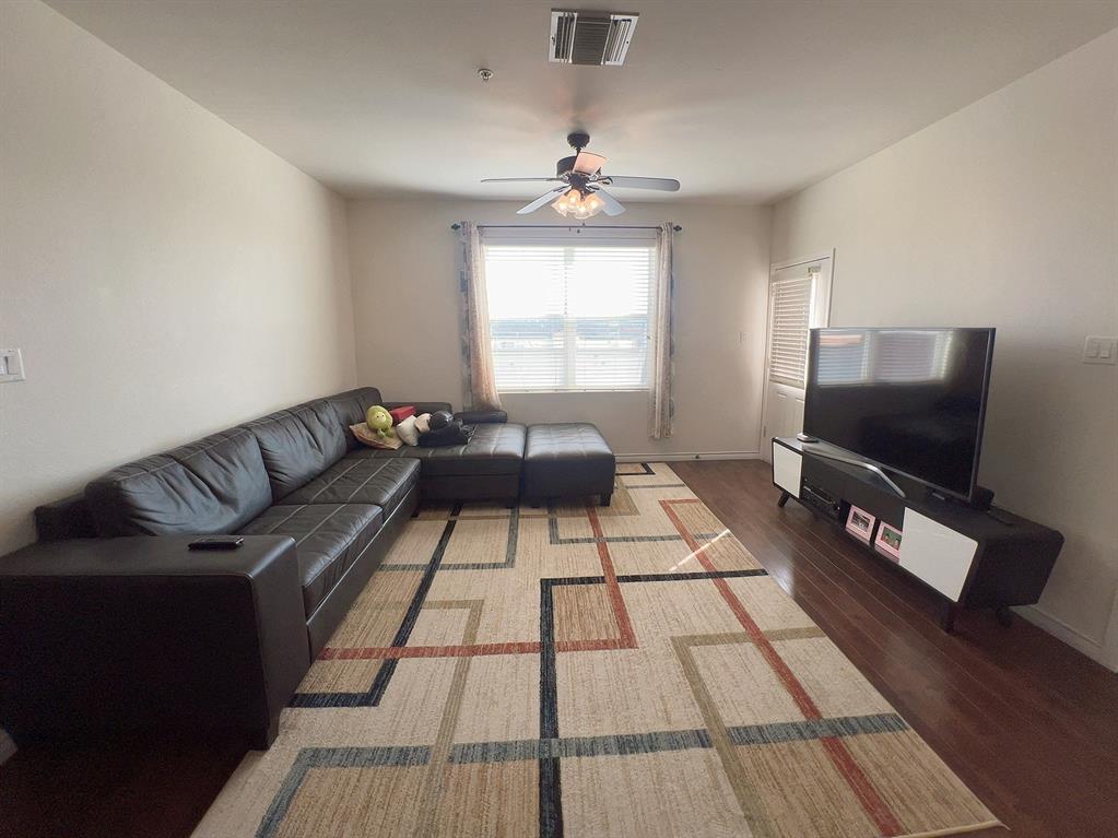 1100 West Trinity Mills Road, Unit 3015 Carrollton, TX 75006 - Photo 5 of 17 a living room with a couch and a flat screen tv