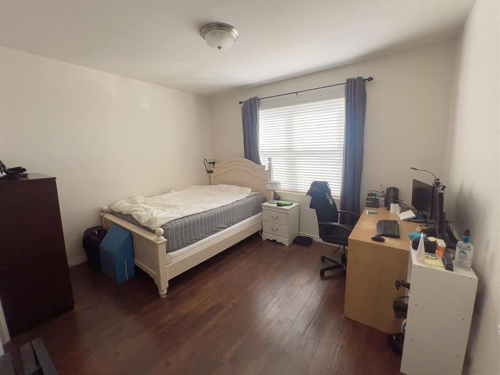 1100 West Trinity Mills Road, Unit 3015 Carrollton, TX 75006 - Photo 9 of 17 a bedroom with a bed and wooden floor