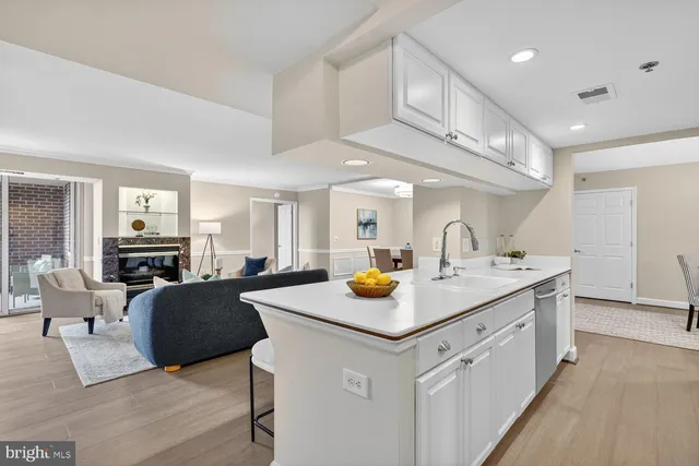 a kitchen with stainless steel appliances a refrigerator a sink a stove a dining table and chairs