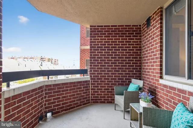 a view of swimming pool with lawn chairs under an umbrella