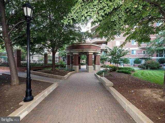 a view of a street with a bench in front of house