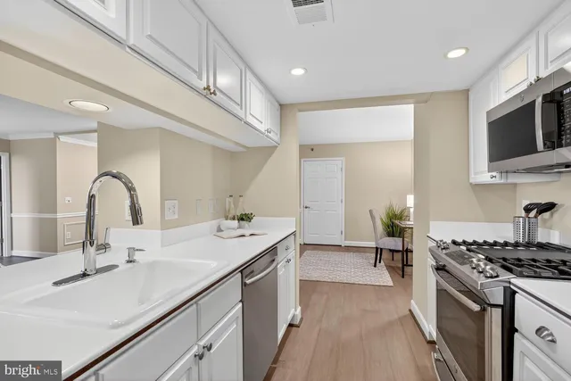 a kitchen with stainless steel appliances a stove microwave and refrigerator