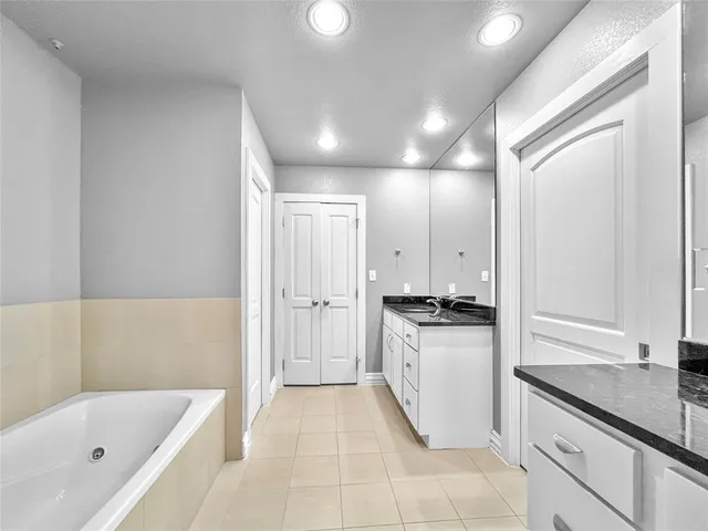 a bathroom with a granite countertop sink mirror and bathtub