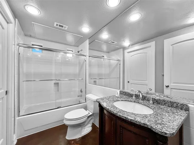 a bathroom with a granite countertop sink toilet and shower