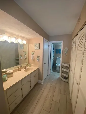 a bathroom with a sink a toilet and a large mirror
