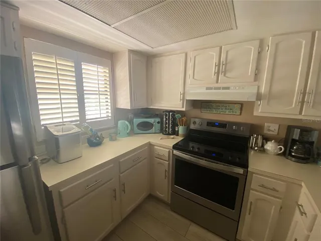 a kitchen with cabinets appliances a sink and a window