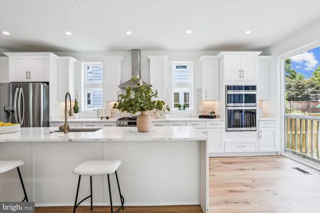 a kitchen with kitchen island a counter top space a sink stainless steel appliances and cabinets