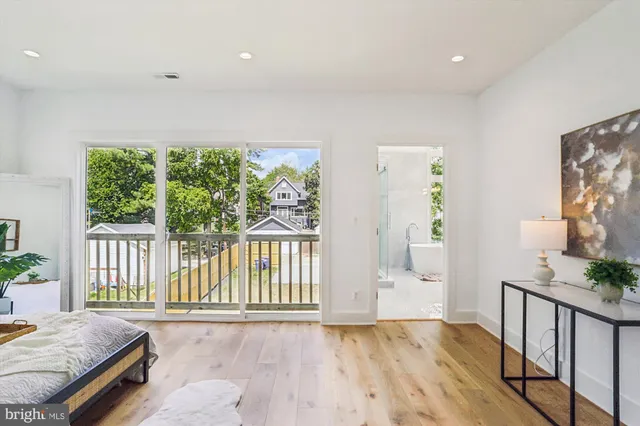 a spacious bedroom with a bed and wooden floor