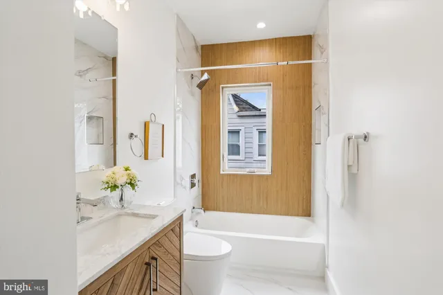 a bathroom with a granite countertop sink a toilet and shower