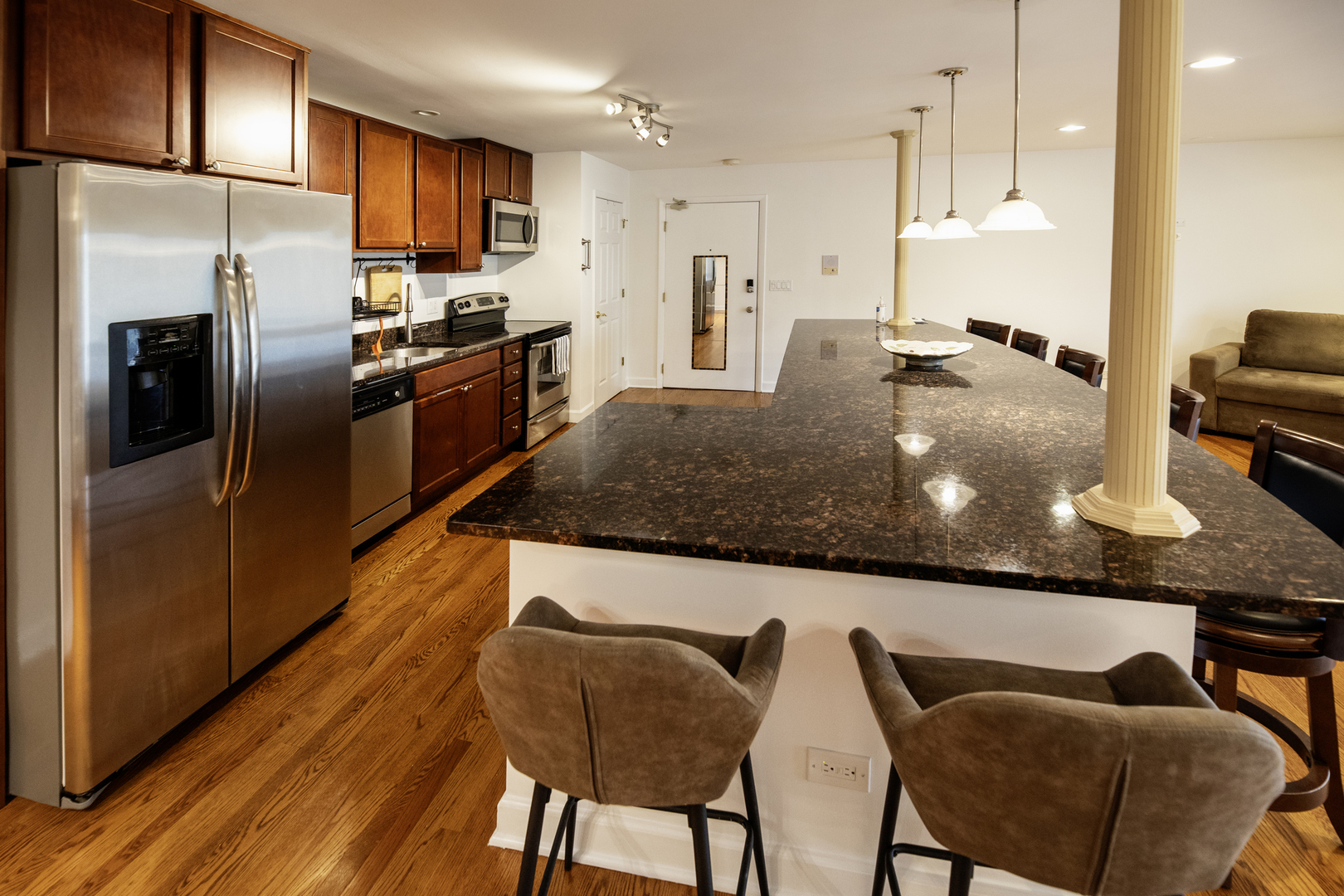 9601 Golf Road, Unit 304 Des Plaines, IL 60016 - Photo 6 of 20 a kitchen with stainless steel appliances granite countertop a table chairs in it and wooden floors