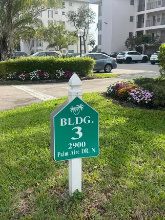 a sign board with a house and yard in the back
