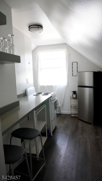 1007 Julia Street Elizabeth, NJ 07201 - Photo 16 of 20 a kitchen with a table chairs refrigerator and microwave