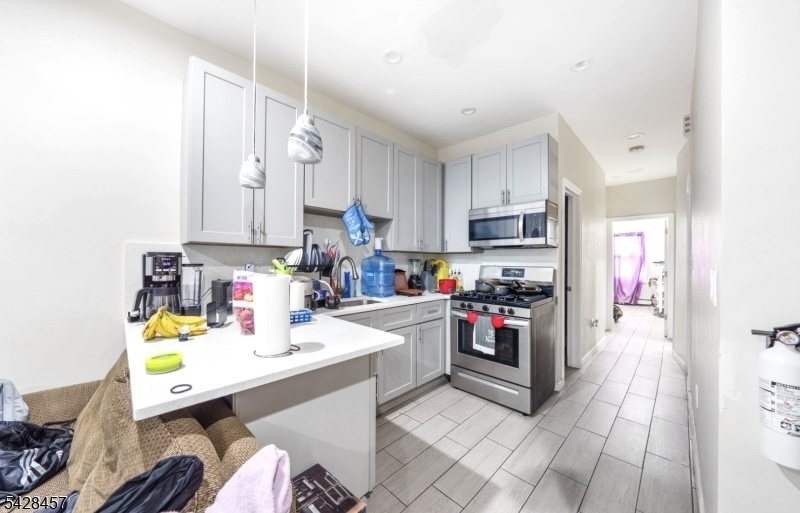 1007 Julia Street Elizabeth, NJ 07201 - Photo 2 of 20 a kitchen with a sink appliances and cabinets