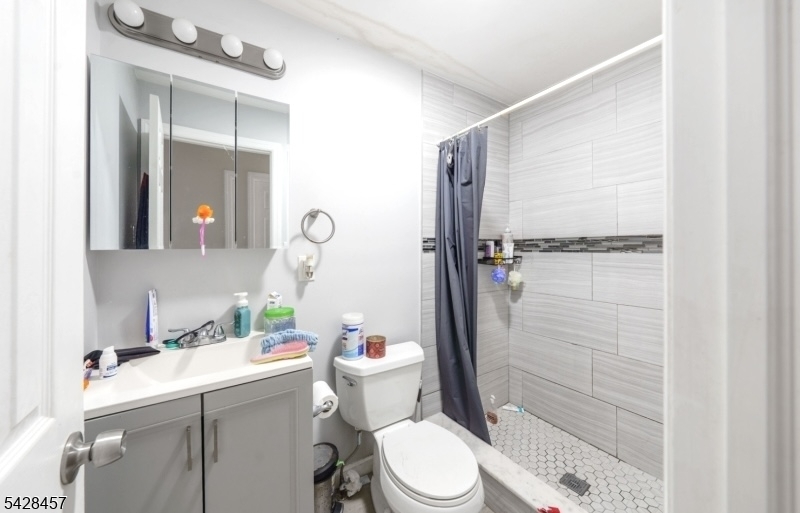 1007 Julia Street Elizabeth, NJ 07201 - Photo 5 of 20 a bathroom with a toilet a sink and shower