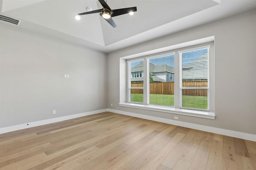 4512 Meander Way Prosper, TX 75078 - Photo 19 of 40 a view of an empty room with a window and wooden floor